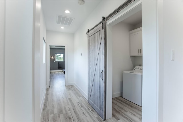 3323 Cornell St, Houston, TX 77022 - washroom with a barn door, cabinet space, light wood-style flooring, independent washer and dryer, and recessed lighting