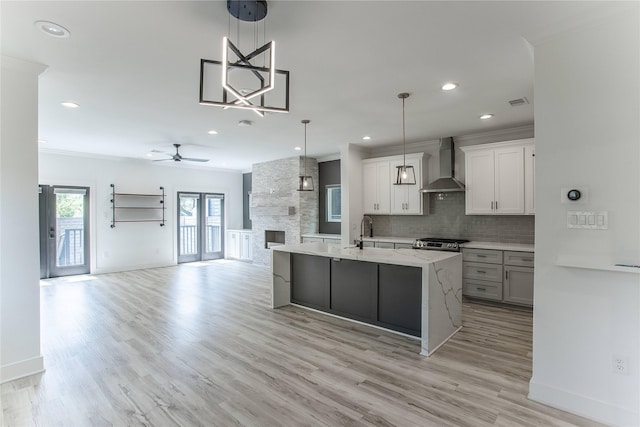 3323 Cornell St, Houston, TX 77022 - kitchen with wall chimney range hood, ornamental molding, ceiling fan, decorative backsplash, and open floor plan