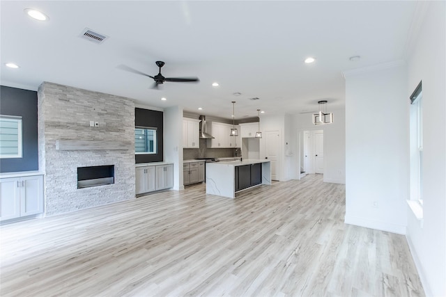 3323 Cornell St, Houston, TX 77022 - unfurnished living room with ornamental molding, a ceiling fan, light wood finished floors, recessed lighting, and a fireplace