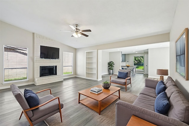 6315 Dellfern Dr, Houston, TX 77035 - living room featuring vaulted ceiling, ceiling fan, wood finished floors, a fireplace, and built in shelves
