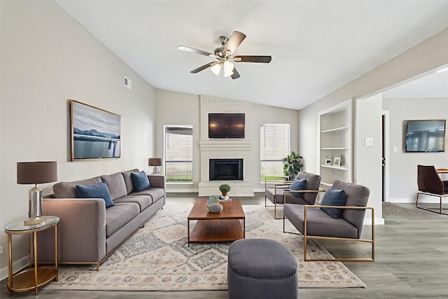 6315 Dellfern Dr, Houston, TX 77035 - living area with a ceiling fan, vaulted ceiling, wood finished floors, a brick fireplace, and built in shelves