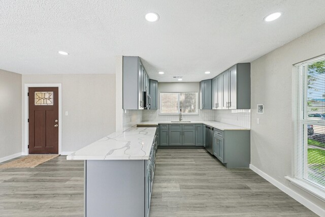6315 Dellfern Dr, Houston, TX 77035 - kitchen featuring gray cabinets, appliances with stainless steel finishes, tasteful backsplash, light stone countertops, and light wood-style floors