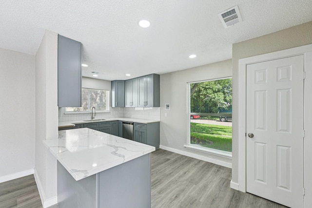 6315 Dellfern Dr, Houston, TX 77035 - kitchen featuring gray cabinets, dishwasher, light stone countertops, a peninsula, and decorative backsplash