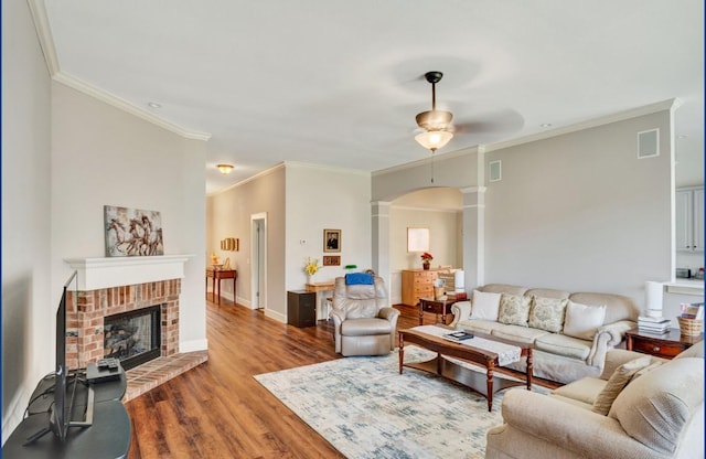 3115 Sable Xing, San Antonio, TX 78232 - living room with wood finished floors, ornamental molding, a ceiling fan, a brick fireplace, and arched walkways