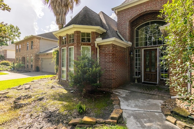 8414 Atascocita Lake Way, Humble, TX 77346 - entrance to property featuring brick siding, roof with shingles, and driveway