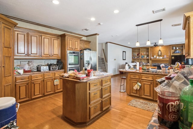 8414 Atascocita Lake Way, Humble, TX 77346 - kitchen featuring stainless steel appliances, brown cabinets, ornamental molding, light wood-style flooring, and recessed lighting