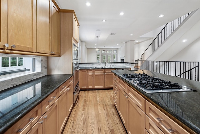 709 Lester St, Houston, TX 77007 - kitchen featuring appliances with stainless steel finishes, light wood-style flooring, recessed lighting, a warming drawer, and dark stone countertops