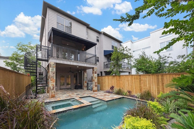 709 Lester St, Houston, TX 77007 - rear view of property featuring stairway, a patio area, stone siding, french doors, and a pool with connected hot tub
