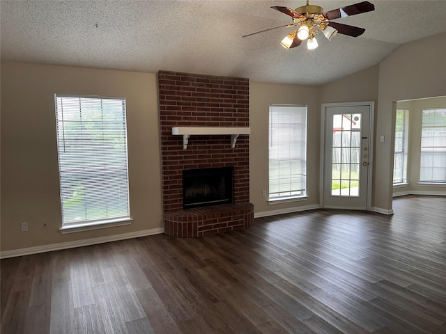 9412 Riviera Dr, Waco, TX 76712 - unfurnished living room featuring a ceiling fan, a textured ceiling, dark wood-type flooring, plenty of natural light, and lofted ceiling