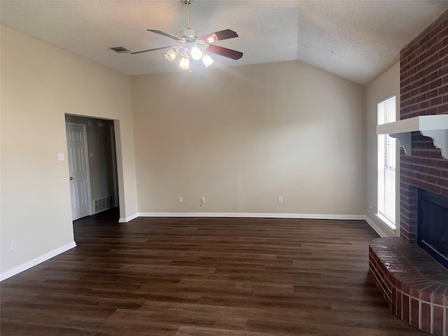 9412 Riviera Dr, Waco, TX 76712 - unfurnished living room featuring a ceiling fan, lofted ceiling, a textured ceiling, dark wood-style flooring, and a brick fireplace