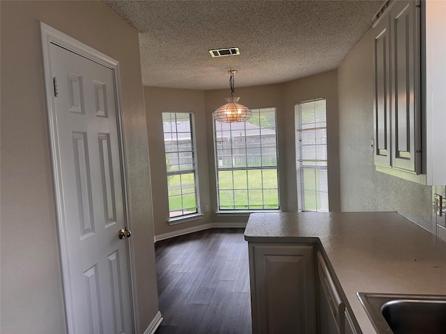 9412 Riviera Dr, Waco, TX 76712 - unfurnished dining area with dark wood finished floors, a textured ceiling, and a textured wall