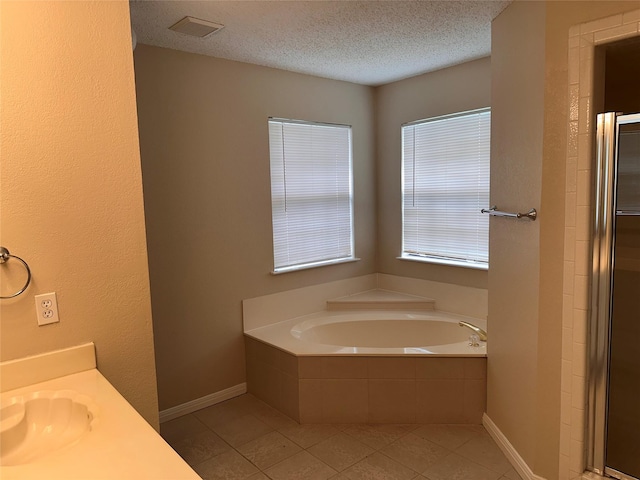 9412 Riviera Dr, Waco, TX 76712 - bathroom featuring tile patterned floors, a bath, a textured ceiling, vanity, and a stall shower