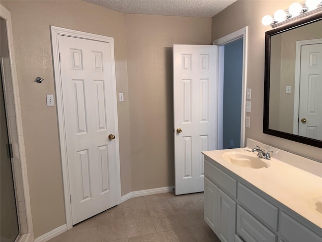 9412 Riviera Dr, Waco, TX 76712 - bathroom with double vanity, a textured ceiling, tile patterned floors, and an enclosed shower