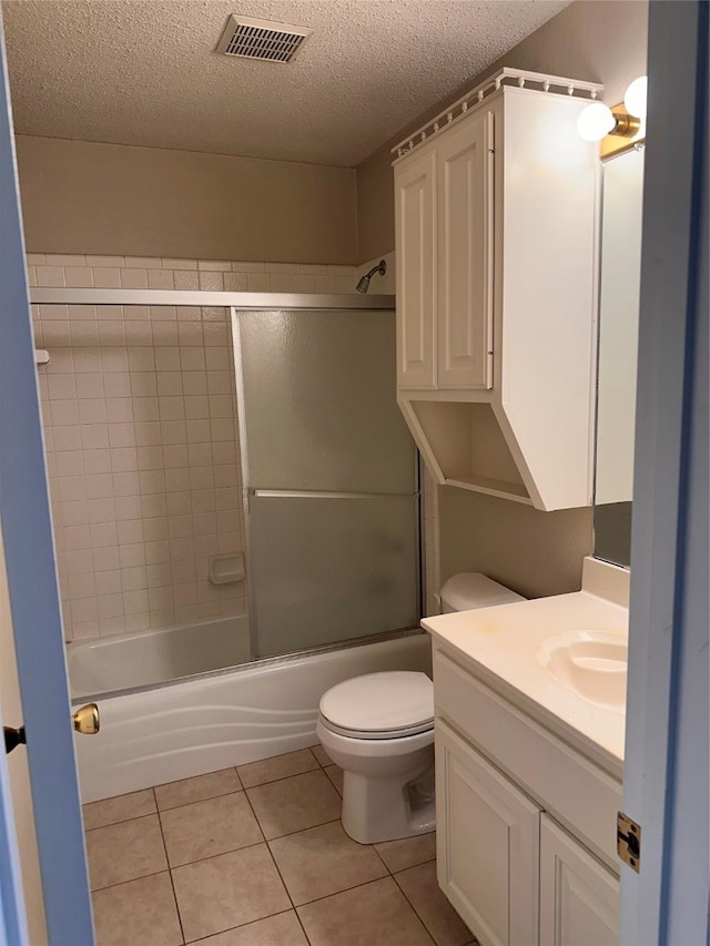 9412 Riviera Dr, Waco, TX 76712 - bathroom featuring vanity, a textured ceiling, enclosed tub / shower combo, and tile patterned floors