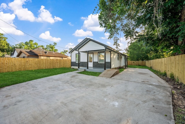 6321 Joe Louis Ln, Houston, TX 77091 - rear view of property with a fenced backyard, concrete driveway, and a patio area
