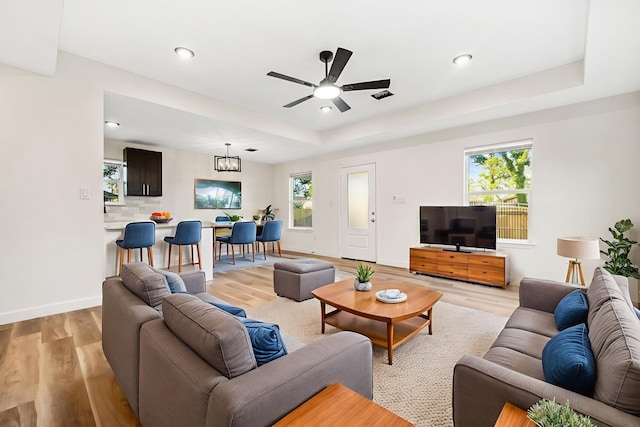 6321 Joe Louis Ln, Houston, TX 77091 - living room with light wood-style floors, a ceiling fan, a raised ceiling, recessed lighting, and a chandelier