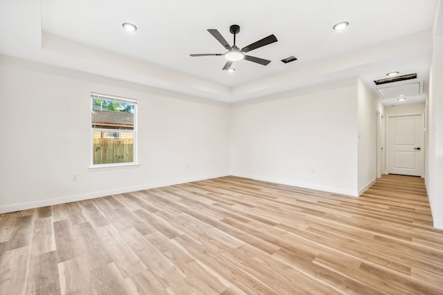 6321 Joe Louis Ln, Houston, TX 77091 - empty room featuring a raised ceiling, light wood-style flooring, ceiling fan, attic access, and recessed lighting