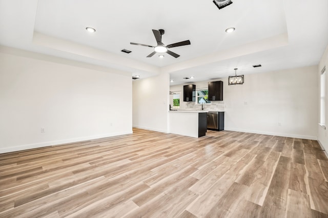 6321 Joe Louis Ln, Houston, TX 77091 - unfurnished living room with ceiling fan, a chandelier, light wood finished floors, recessed lighting, and a tray ceiling