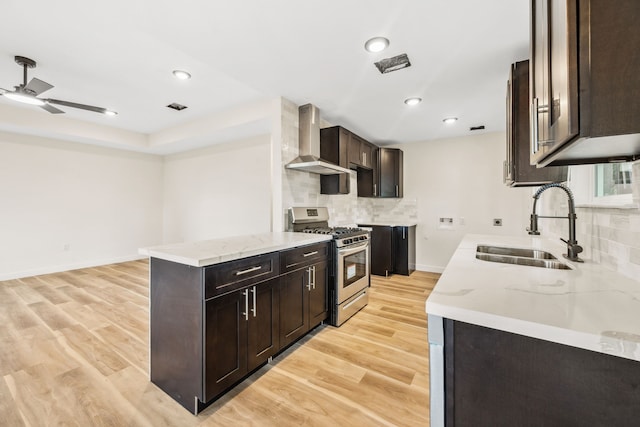 6321 Joe Louis Ln, Houston, TX 77091 - kitchen featuring stainless steel range with gas cooktop, wall chimney range hood, dark brown cabinets, backsplash, and ceiling fan
