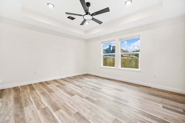 6321 Joe Louis Ln, Houston, TX 77091 - empty room featuring a tray ceiling, ceiling fan, recessed lighting, and light wood-type flooring