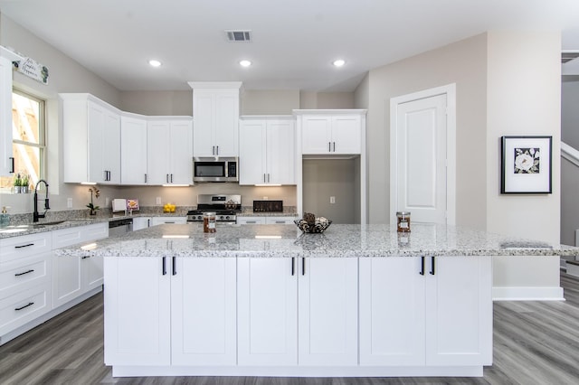 4910 Wunder Way, Houston, TX 77069 - kitchen featuring appliances with stainless steel finishes, white cabinets, light wood-type flooring, and recessed lighting