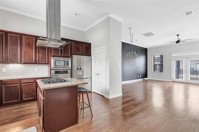 3204 Garden Oaks Vw, Houston, TX 77018 - kitchen with stainless steel appliances, ceiling fan, ornamental molding, island range hood, and a center island