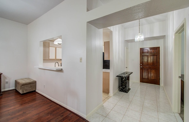 3618 Teakwood Ln, Pearland, TX 77584 - corridor with a chandelier and light wood finished floors