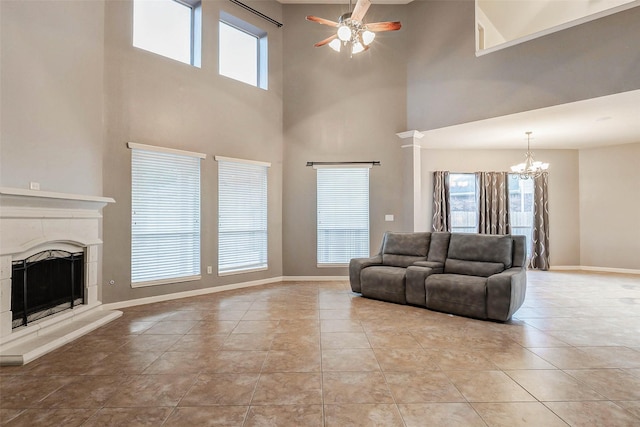 2226 Arrowwood Trl, Katy, TX 77494 - living room with a ceiling fan, a chandelier, a high ceiling, a fireplace with raised hearth, and tile patterned flooring
