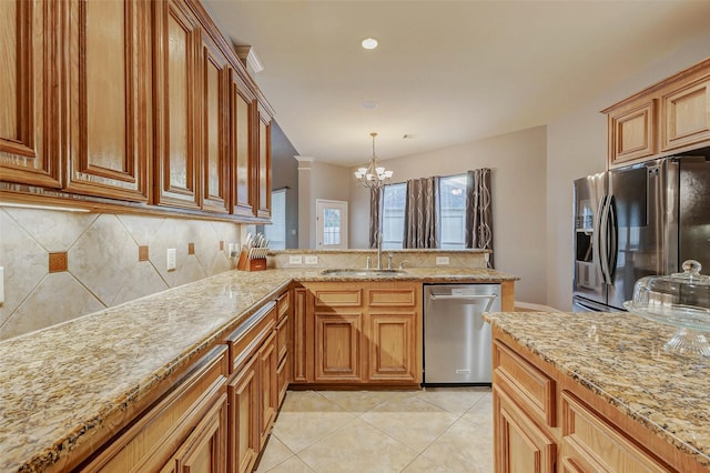 2226 Arrowwood Trl, Katy, TX 77494 - kitchen with appliances with stainless steel finishes, a chandelier, backsplash, a peninsula, and light stone counters