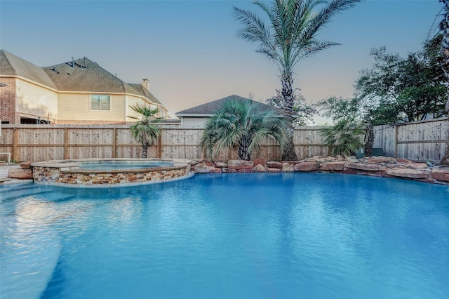 2226 Arrowwood Trl, Katy, TX 77494 - pool at dusk with a pool with connected hot tub and a fenced backyard