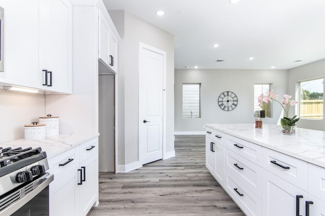 15034 Wunderlust Ln, Houston, TX 77069 - kitchen with gas stove, white cabinetry, light stone counters, light wood-style floors, and recessed lighting