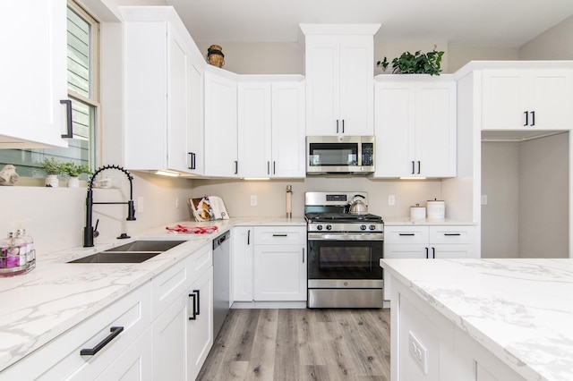 15034 Wunderlust Ln, Houston, TX 77069 - kitchen with appliances with stainless steel finishes, light wood-style floors, white cabinetry, and light stone counters