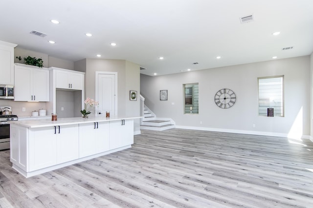 15034 Wunderlust Ln, Houston, TX 77069 - kitchen featuring stainless steel appliances, light wood-style flooring, recessed lighting, a kitchen island, and light countertops