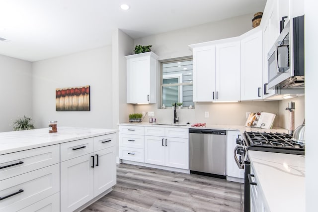 15034 Wunderlust Ln, Houston, TX 77069 - kitchen featuring appliances with stainless steel finishes, white cabinets, light wood-style flooring, light stone counters, and recessed lighting