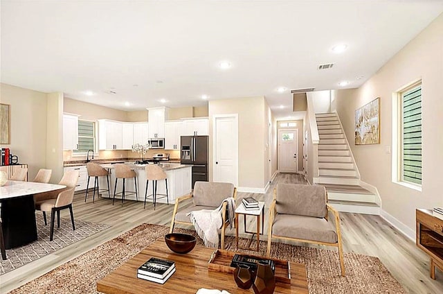 15034 Wunderlust Ln, Houston, TX 77069 - living room featuring light wood-type flooring, stairway, and recessed lighting