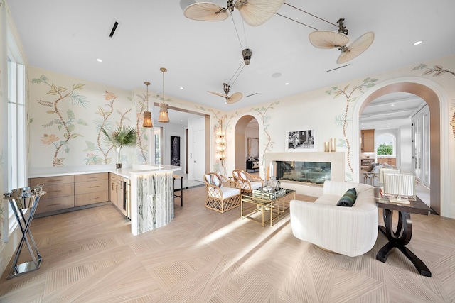 3649 Chevy Chase Dr, Houston, TX 77019 - living area with arched walkways, recessed lighting, a glass covered fireplace, and a ceiling fan