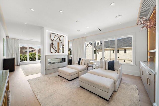 3649 Chevy Chase Dr, Houston, TX 77019 - living room with a glass covered fireplace, recessed lighting, and light wood-type flooring