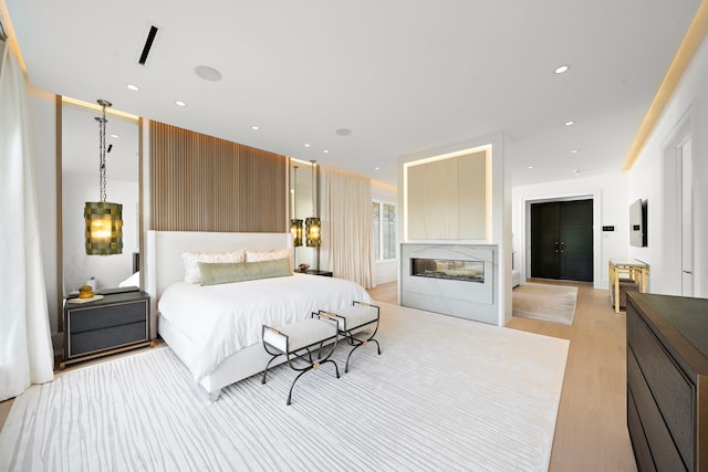 3649 Chevy Chase Dr, Houston, TX 77019 - bedroom featuring light wood-type flooring, a multi sided fireplace, and recessed lighting