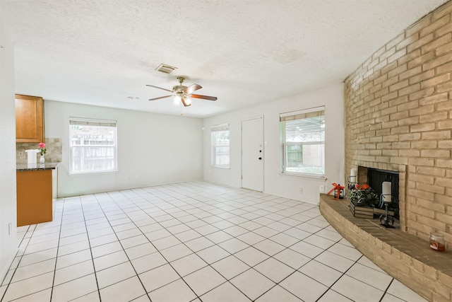 11611 Old Telegraph Rd, Houston, TX 77067 - unfurnished living room with a fireplace, a ceiling fan, a textured ceiling, and light tile patterned flooring
