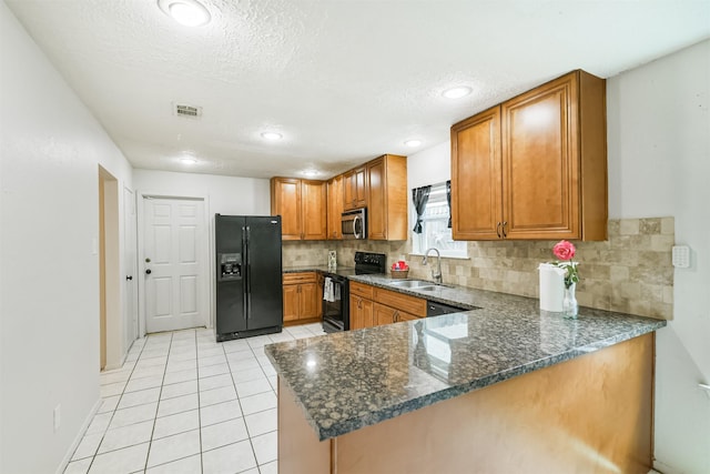 11611 Old Telegraph Rd, Houston, TX 77067 - kitchen with black appliances, brown cabinets, backsplash, dark stone counters, and a textured ceiling