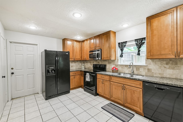 11611 Old Telegraph Rd, Houston, TX 77067 - kitchen featuring black appliances, a textured ceiling, brown cabinetry, decorative backsplash, and dark stone countertops