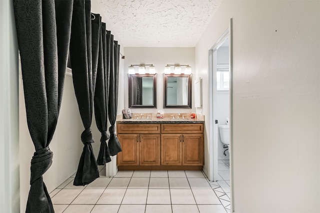 11611 Old Telegraph Rd, Houston, TX 77067 - full bathroom featuring double vanity, a textured ceiling, and tile patterned flooring
