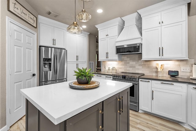 3829 Evergreen Way, Montgomery, TX 77356 - kitchen featuring stainless steel appliances, custom range hood, white cabinetry, decorative backsplash, and recessed lighting