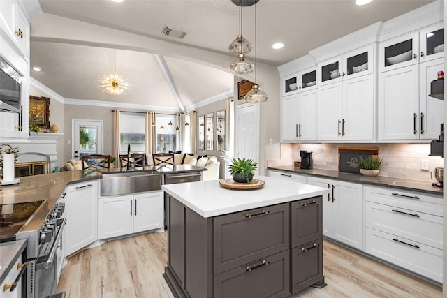 3829 Evergreen Way, Montgomery, TX 77356 - kitchen with lofted ceiling, stainless steel range with electric stovetop, crown molding, tasteful backsplash, and gray cabinetry