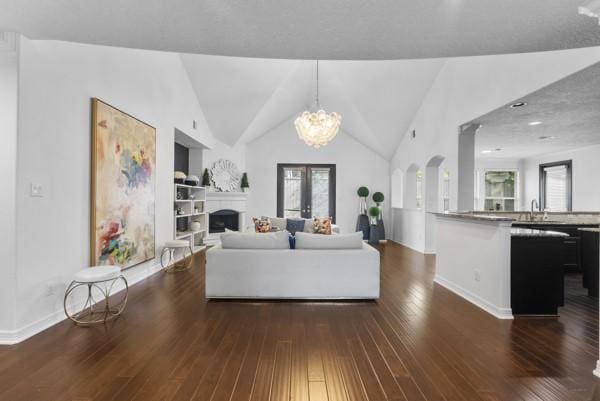 2523 Watts St, Houston, TX 77030 - living area featuring dark wood-style floors, a chandelier, a fireplace, built in features, and lofted ceiling