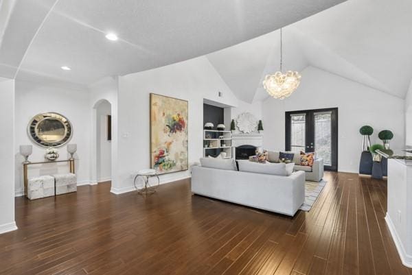 2523 Watts St, Houston, TX 77030 - living room featuring arched walkways, hardwood / wood-style floors, a chandelier, lofted ceiling, and built in shelves