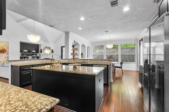 2523 Watts St, Houston, TX 77030 - kitchen with appliances with stainless steel finishes, a large island, a chandelier, dark wood finished floors, and lofted ceiling