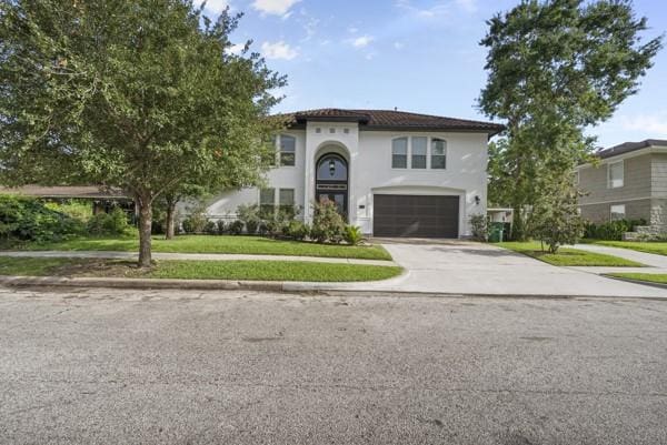2523 Watts St, Houston, TX 77030 - mediterranean / spanish home featuring driveway, an attached garage, a front yard, and stucco siding