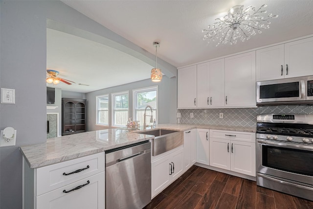 16410 Great Frst, Humble, TX 77346 - kitchen featuring stainless steel appliances, a peninsula, dark wood-style flooring, decorative backsplash, and light stone countertops