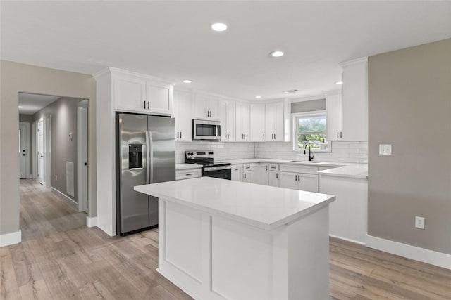 318 Primrose Rd, Jones Creek, TX 77541 - kitchen with stainless steel appliances, light wood-style flooring, decorative backsplash, white cabinets, and recessed lighting